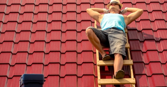 man on top of roof during the summer